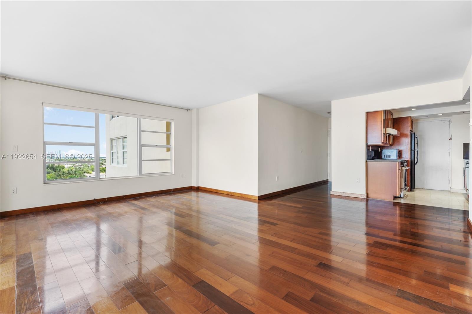 11111 Biscayne Boulevard, Unit 10H Miami, FL 33181 - Photo 3 of 22 a view of empty room with wooden floor and fan