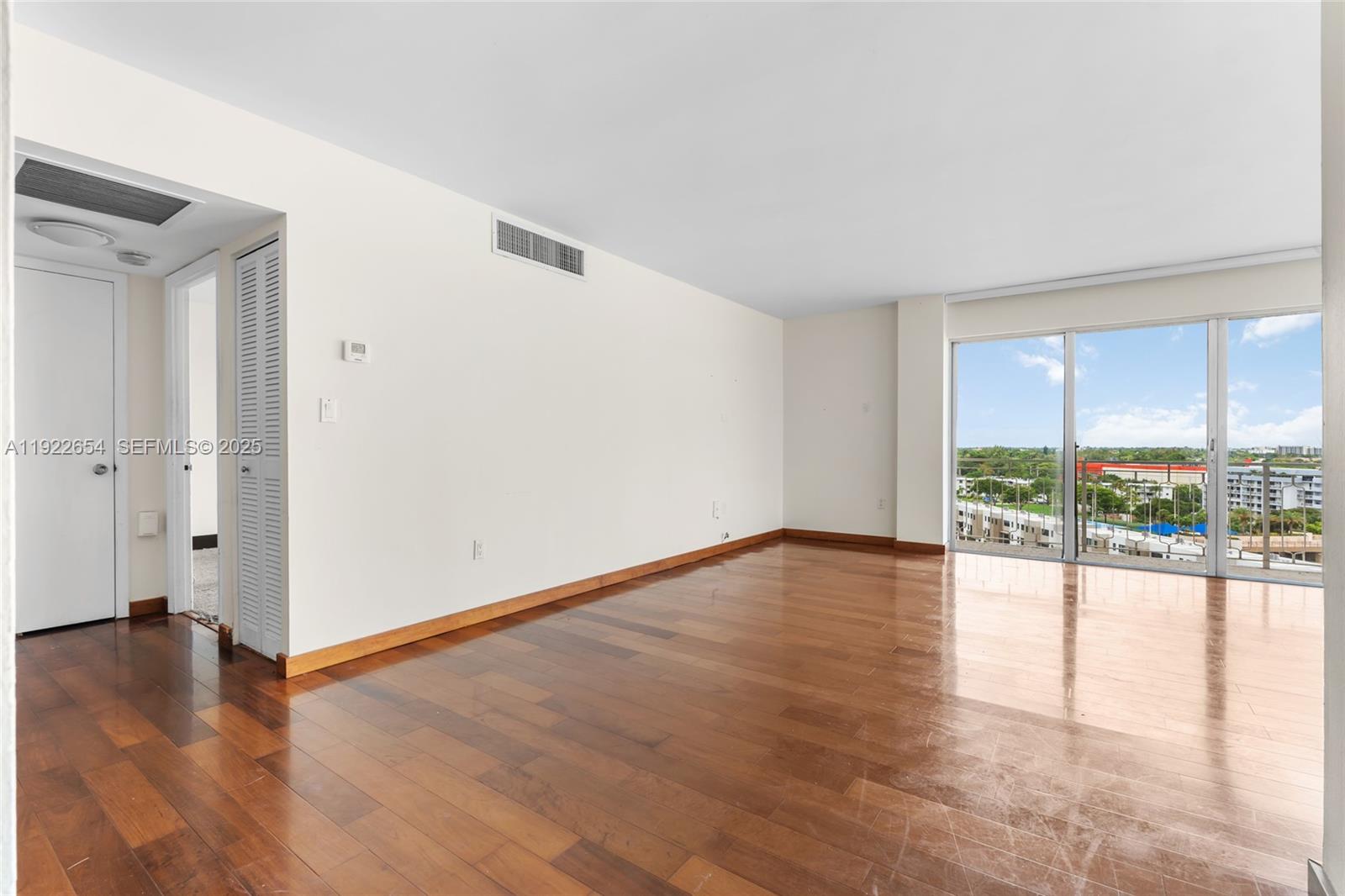11111 Biscayne Boulevard, Unit 10H Miami, FL 33181 - Photo 7 of 22 wooden floor in an empty room with a window