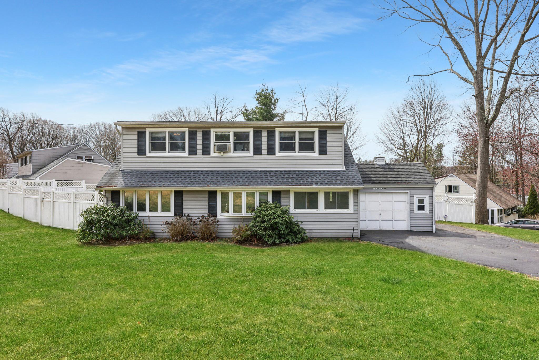 a front view of a house with a garden and trees