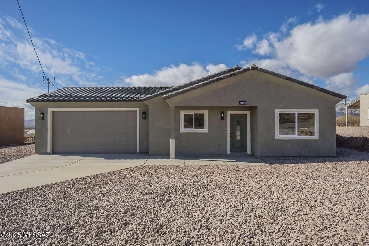 1796 Cajeme Court Rio Rico, AZ 85648 - Photo 1 of 45 a front view of a house with a yard and garage