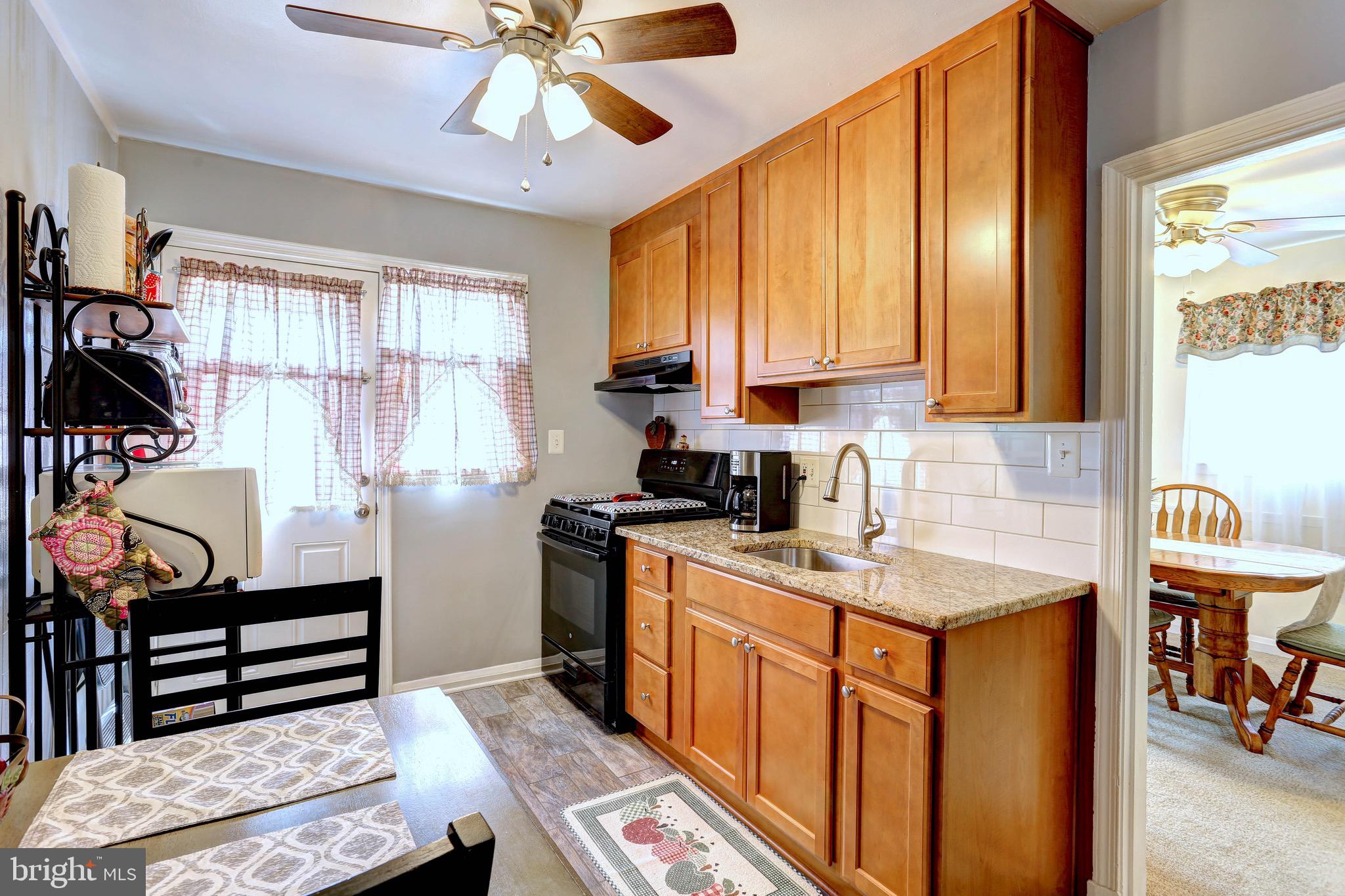 123 Garden Ridge Road Baltimore, MD 21228 - Photo 7 of 29 a kitchen with stainless steel appliances granite countertop a sink stove and cabinets