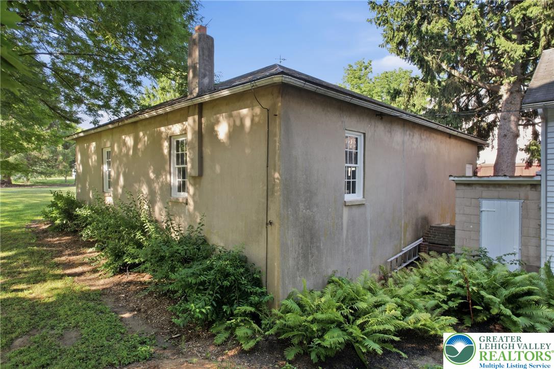 4682 Steuben Road Bethlehem, PA 18020 - Photo 60 of 79 A well-maintained stucco building with classic windows is set amidst mature trees and lush green landscaping.