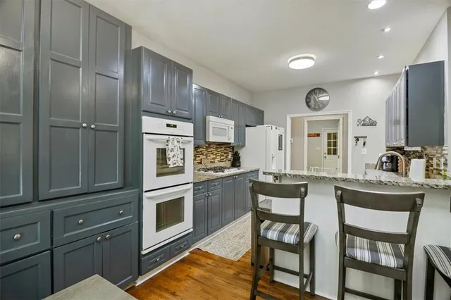 a kitchen with granite countertop a refrigerator stove top oven and sink
