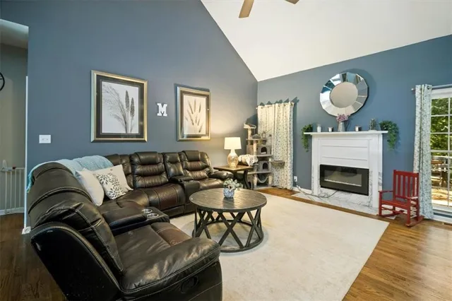 a living room with furniture a fireplace and a flat screen tv