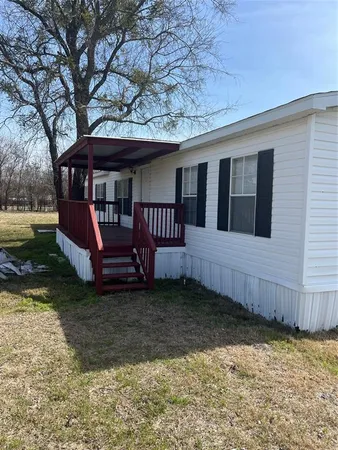 a view of a house with a yard and furniture