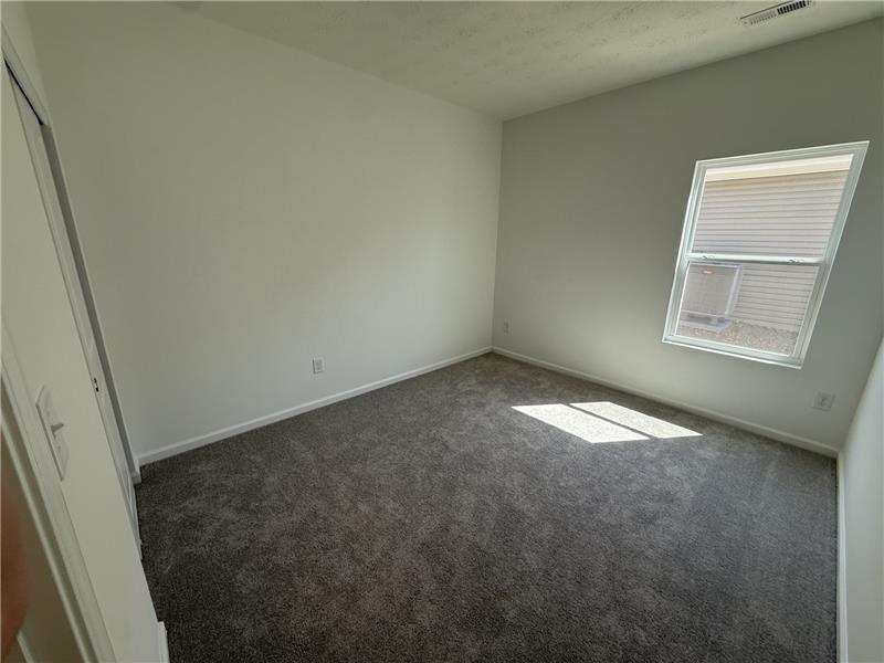 4001 Chakeres Avenue Springfield, OH 45505 - Photo 13 of 15 This cozy bedroom features plush carpeting and a bright window, creating a serene and inviting atmosphere.