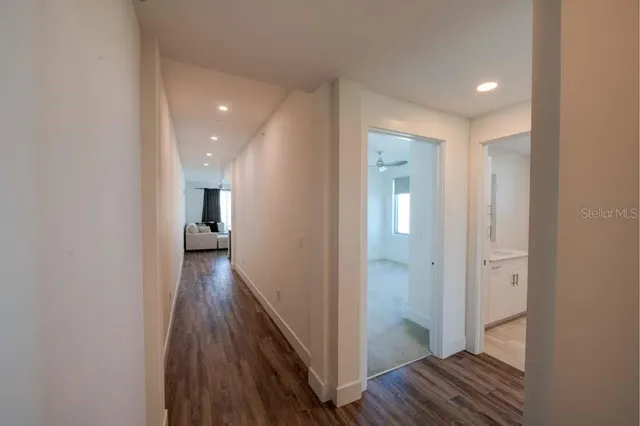 a view of a hallway with wooden floor and staircase