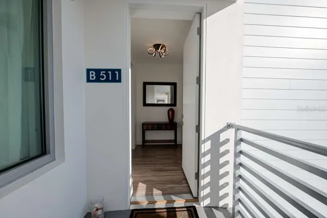 a view of a hallway with wooden floor and staircase