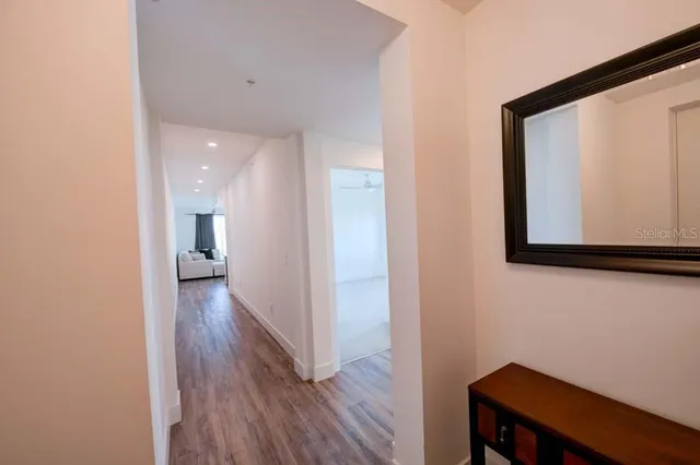 a view of a hallway with wooden floor and closet