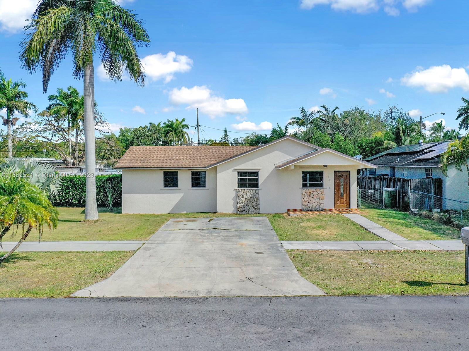 131 Northeast 17th Street Homestead, FL 33030 - Photo 1 of 24 a front view of a house with a yard and garage
