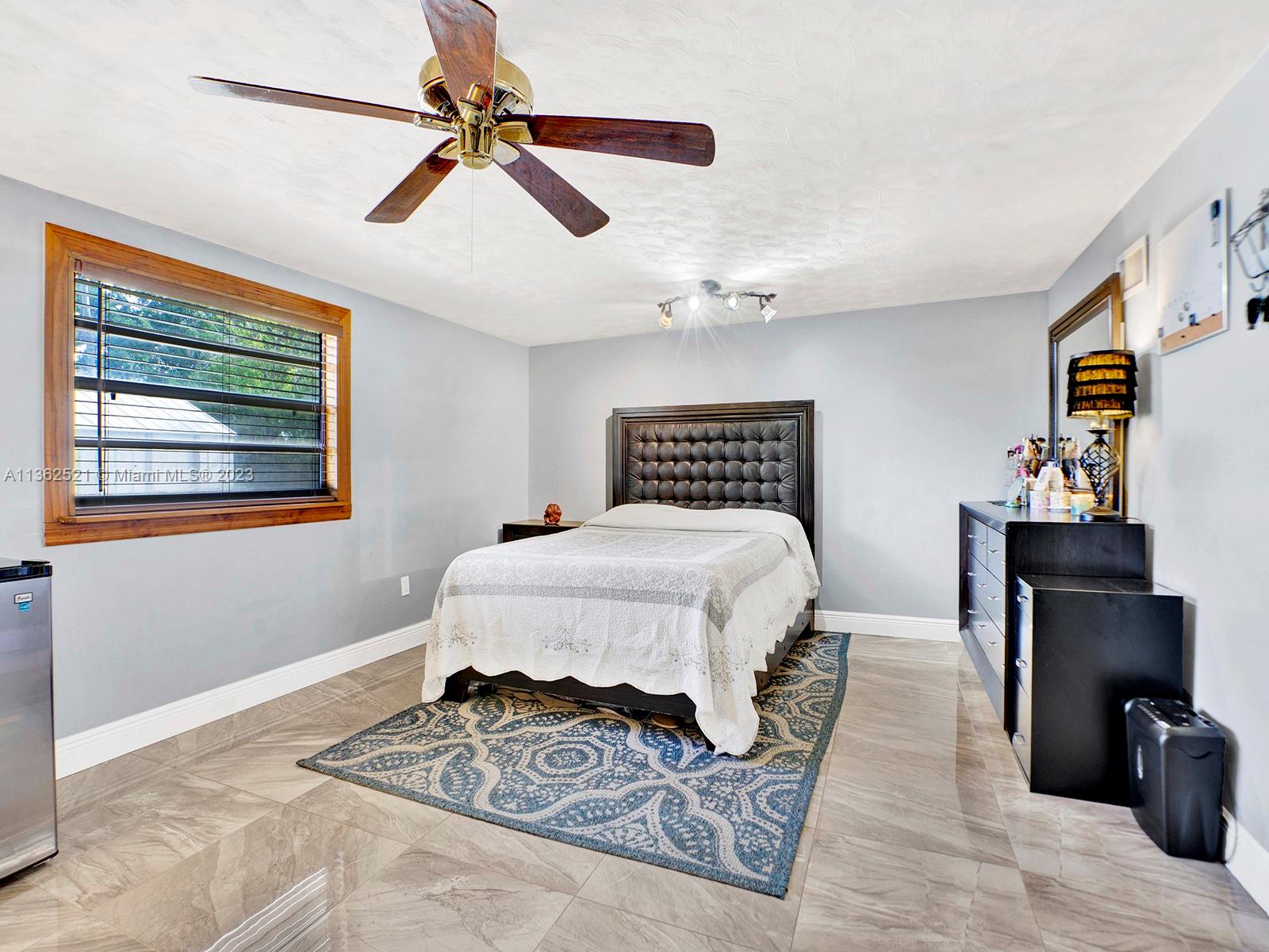 131 Northeast 17th Street Homestead, FL 33030 - Photo 12 of 24 a bedroom with a bed and wooden floor
