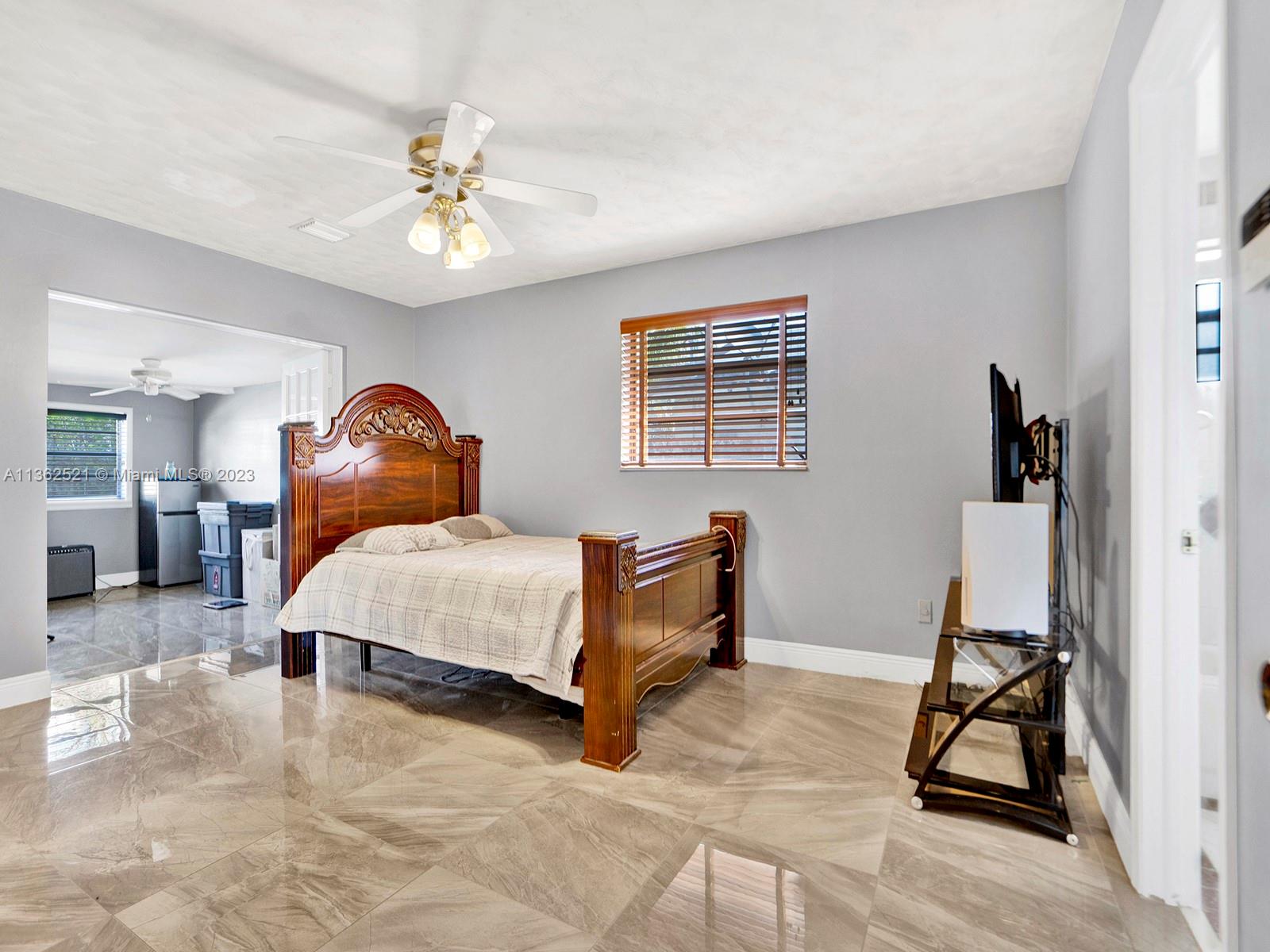 131 Northeast 17th Street Homestead, FL 33030 - Photo 15 of 24 a bedroom with furniture and a chandelier