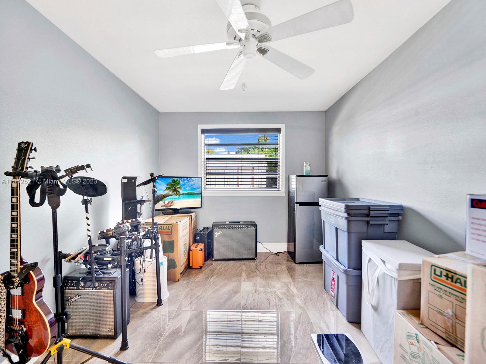 131 Northeast 17th Street Homestead, FL 33030 - Photo 16 of 24 a bedroom with furniture a flat screen tv and a window
