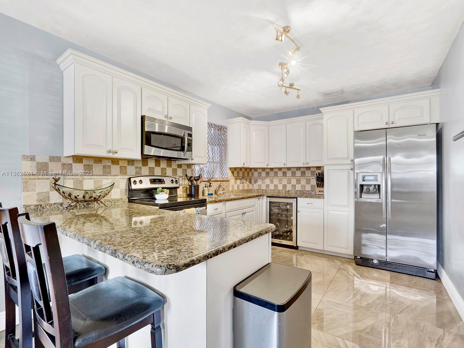 131 Northeast 17th Street Homestead, FL 33030 - Photo 5 of 24 a kitchen with kitchen island a counter top space appliances and cabinets