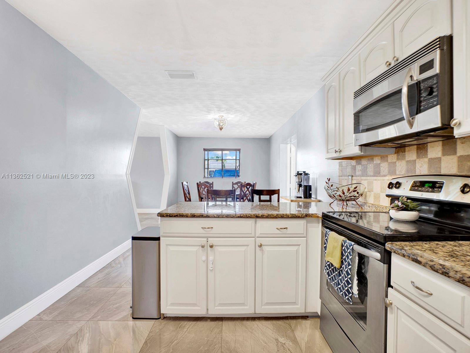 131 Northeast 17th Street Homestead, FL 33030 - Photo 7 of 24 a kitchen with stainless steel appliances granite countertop a sink and cabinets
