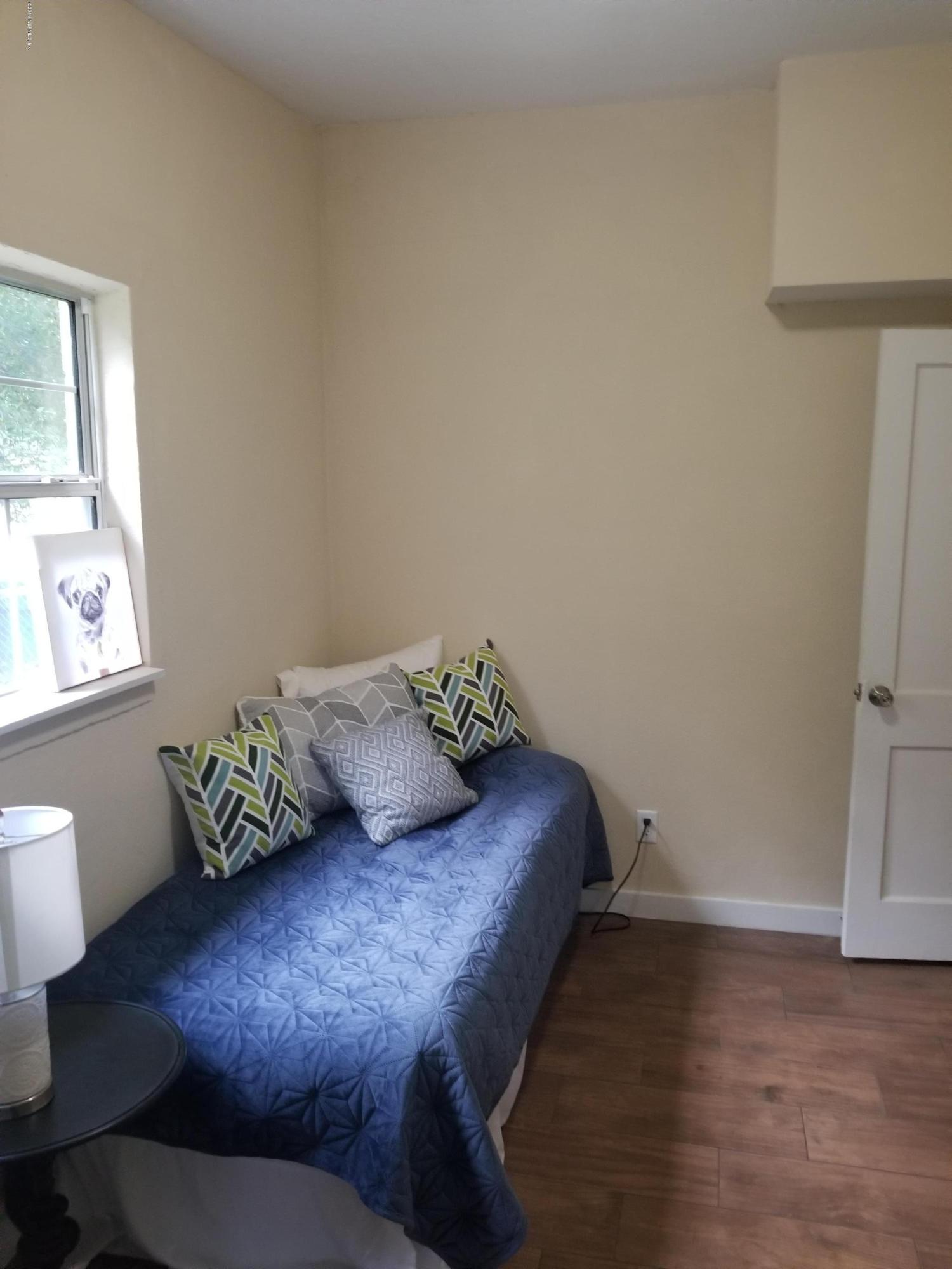 1847 Griflet Road Jacksonville, FL 32211 - Photo 24 of 32 a bed sitting in a bedroom next to a window