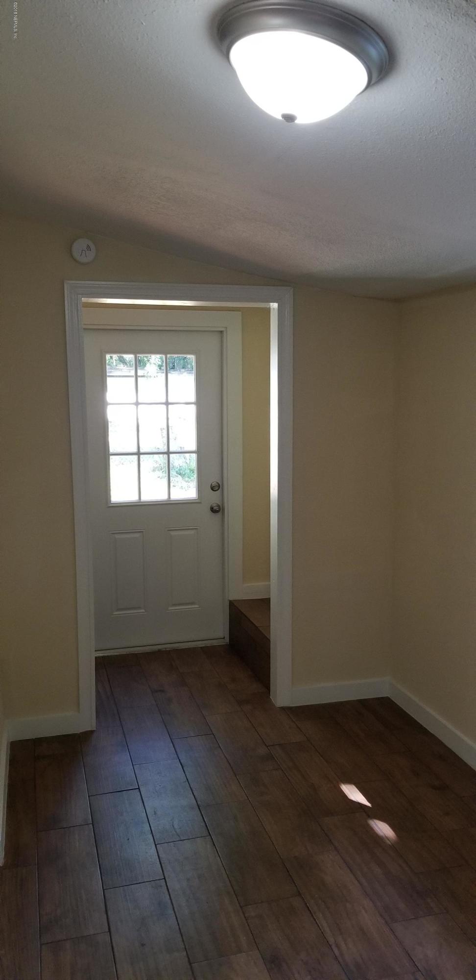 1847 Griflet Road Jacksonville, FL 32211 - Photo 27 of 32 an empty room with wooden floor and windows