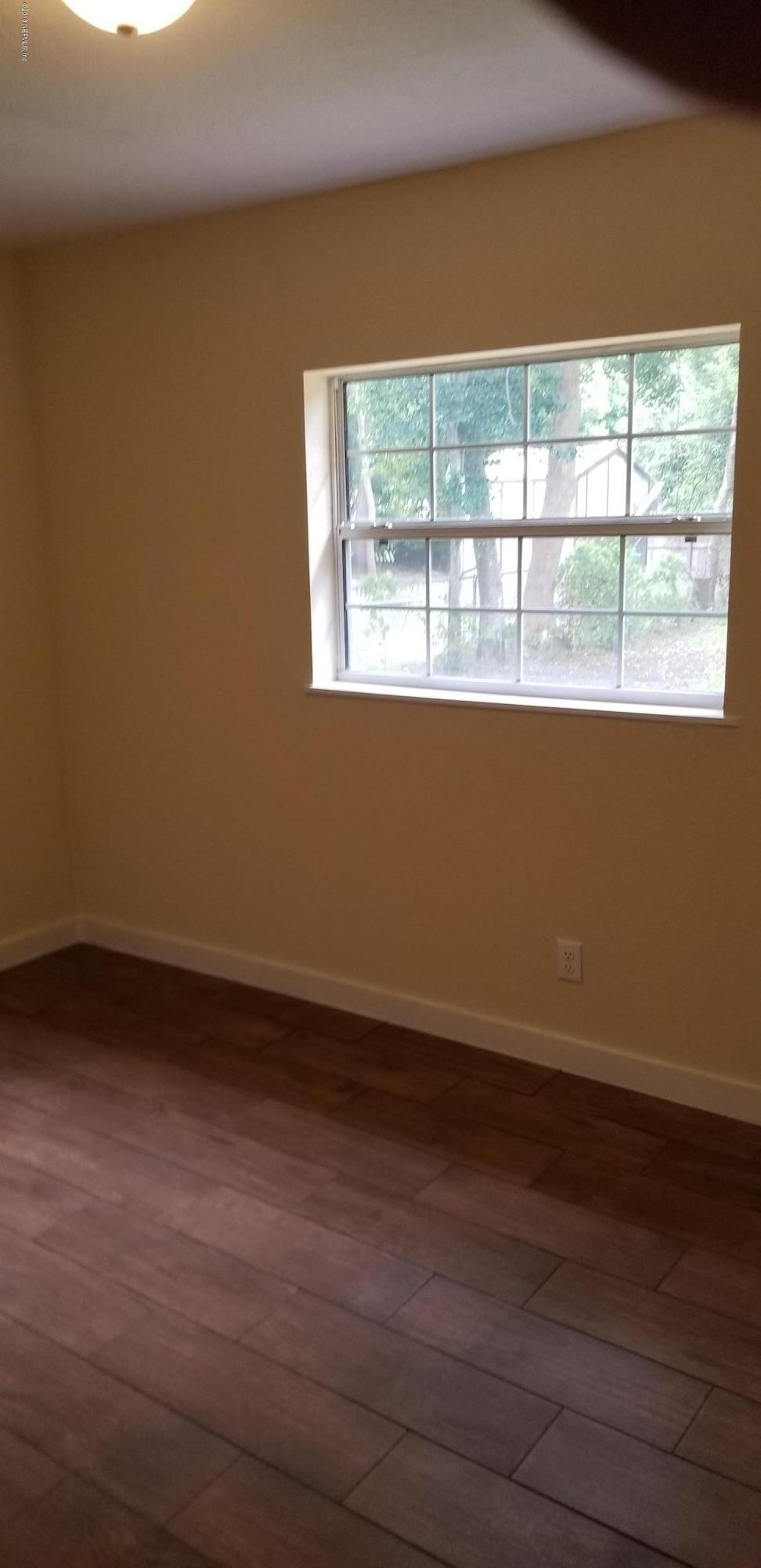 1847 Griflet Road Jacksonville, FL 32211 - Photo 30 of 32 a view of an empty room with wooden floor and a window