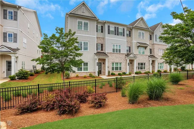 a front view of a house with a garden and lake view