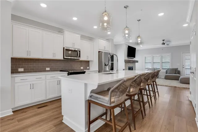 a kitchen with stainless steel appliances granite countertop a stove a sink a microwave a center island and furniture