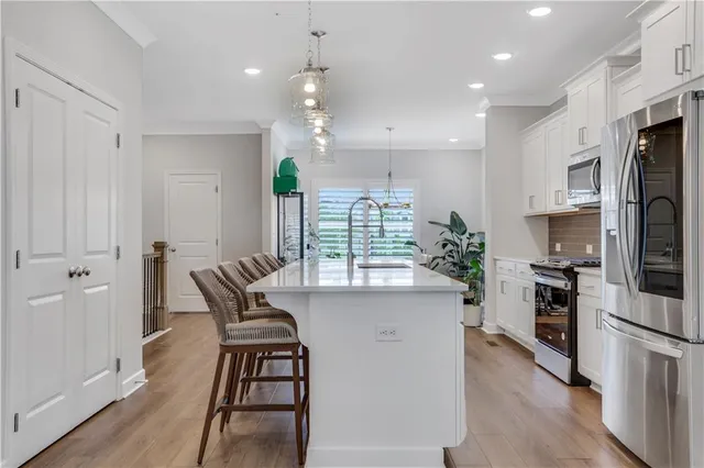a kitchen with a table chairs refrigerator and microwave