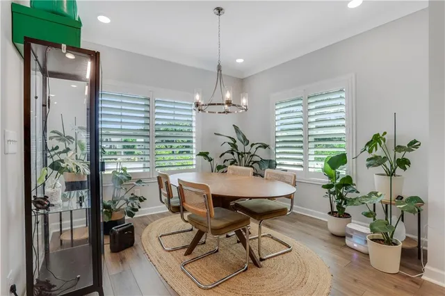 a dining room with furniture potted plants and wooden floor