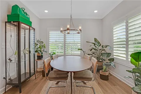 a dining room with furniture potted plants and wooden floor