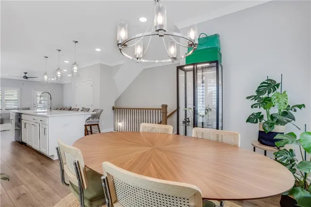 a large white kitchen with a white stove a sink a dining table and chairs