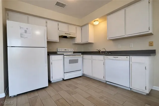 a white refrigerator freezer sitting inside of a kitchen