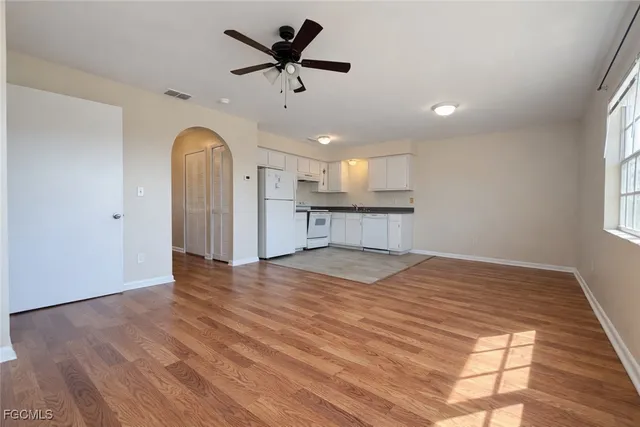 a view of empty room with wooden floor and window