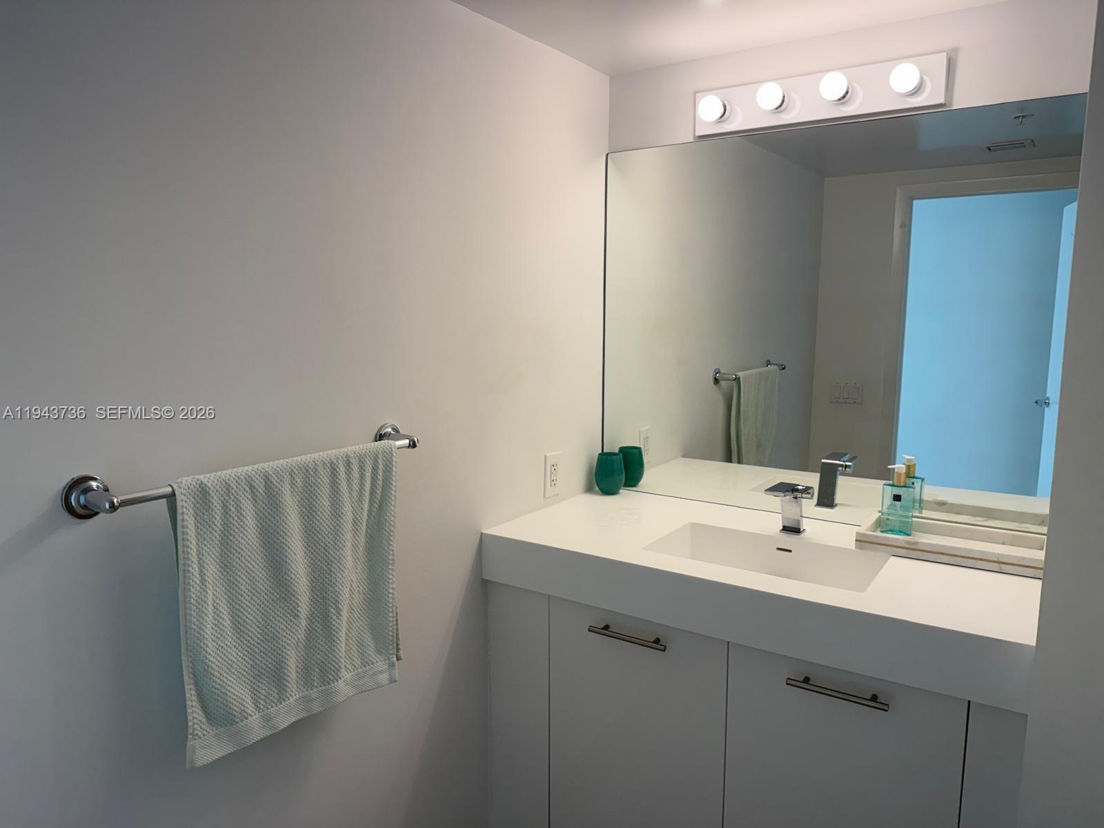 41 Southeast 5th Street, Unit 2010 Miami, FL 33131 - Photo 21 of 58 a bathroom with a sink a mirror and vanity