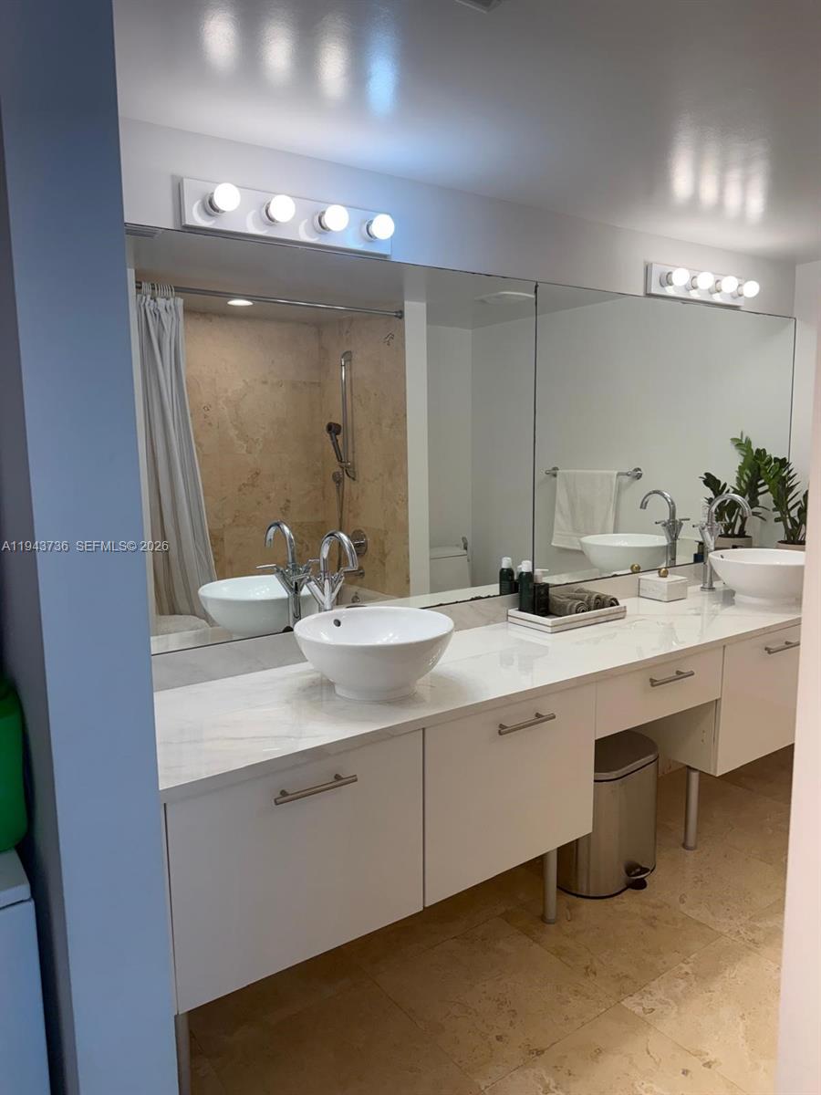 41 Southeast 5th Street, Unit 2010 Miami, FL 33131 - Photo 22 of 58 a bathroom with a double vanity sink and a mirror