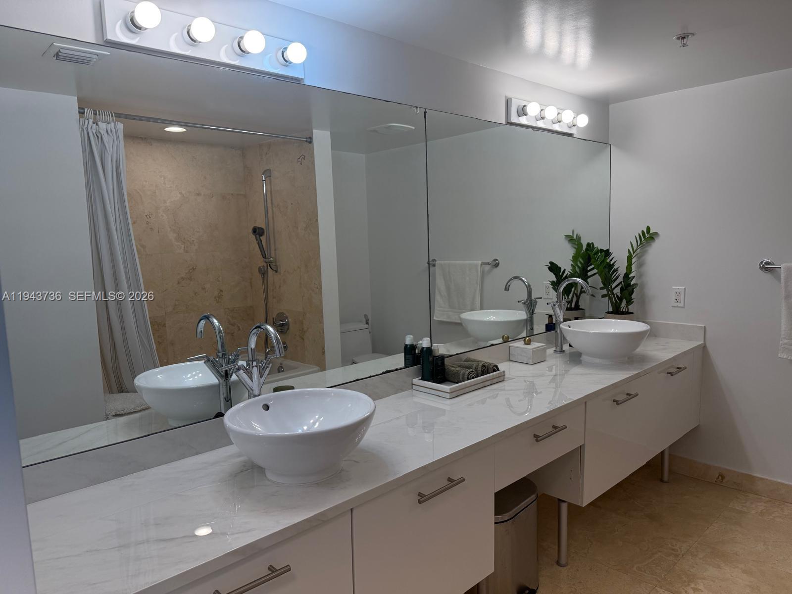 41 Southeast 5th Street, Unit 2010 Miami, FL 33131 - Photo 24 of 58 a bathroom with a double vanity sink and a mirror