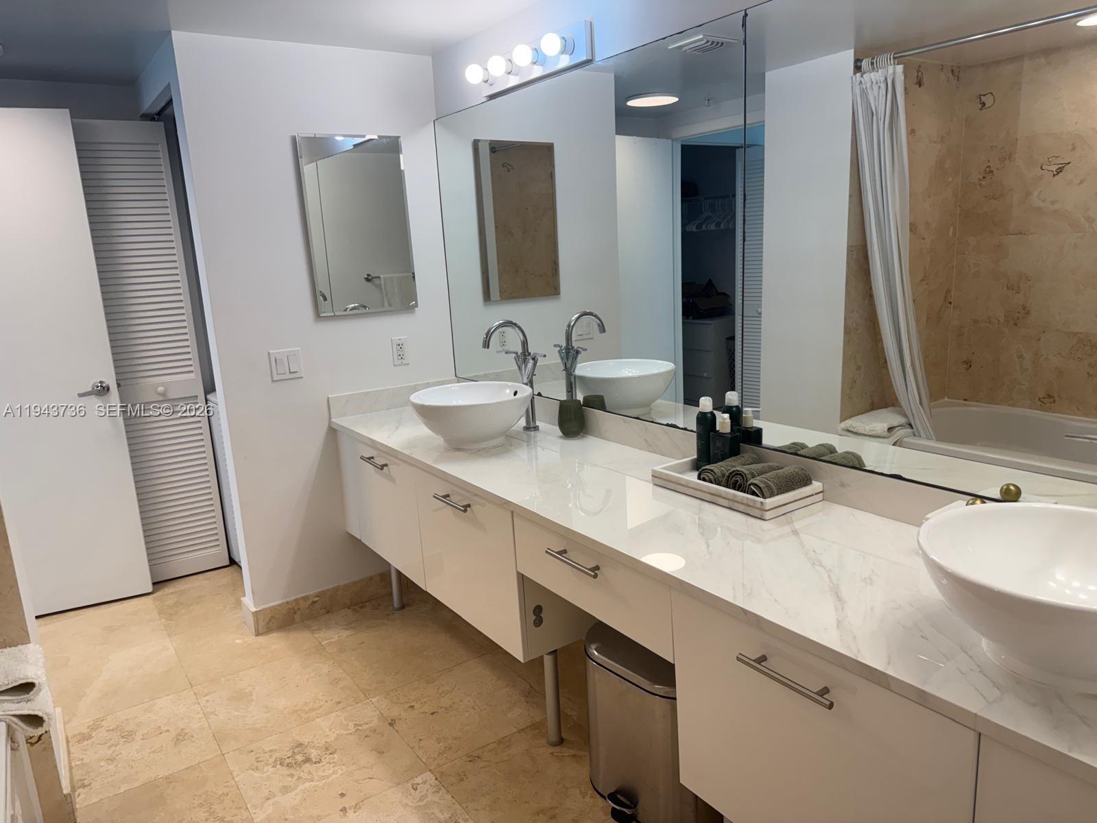 41 Southeast 5th Street, Unit 2010 Miami, FL 33131 - Photo 27 of 58 a bathroom with double vanity and a mirror