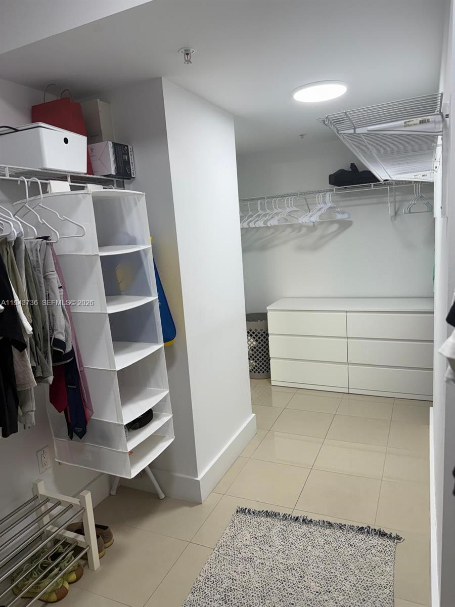 41 Southeast 5th Street, Unit 2010 Miami, FL 33131 - Photo 28 of 58 a view of walk in closet with clothes and shoes