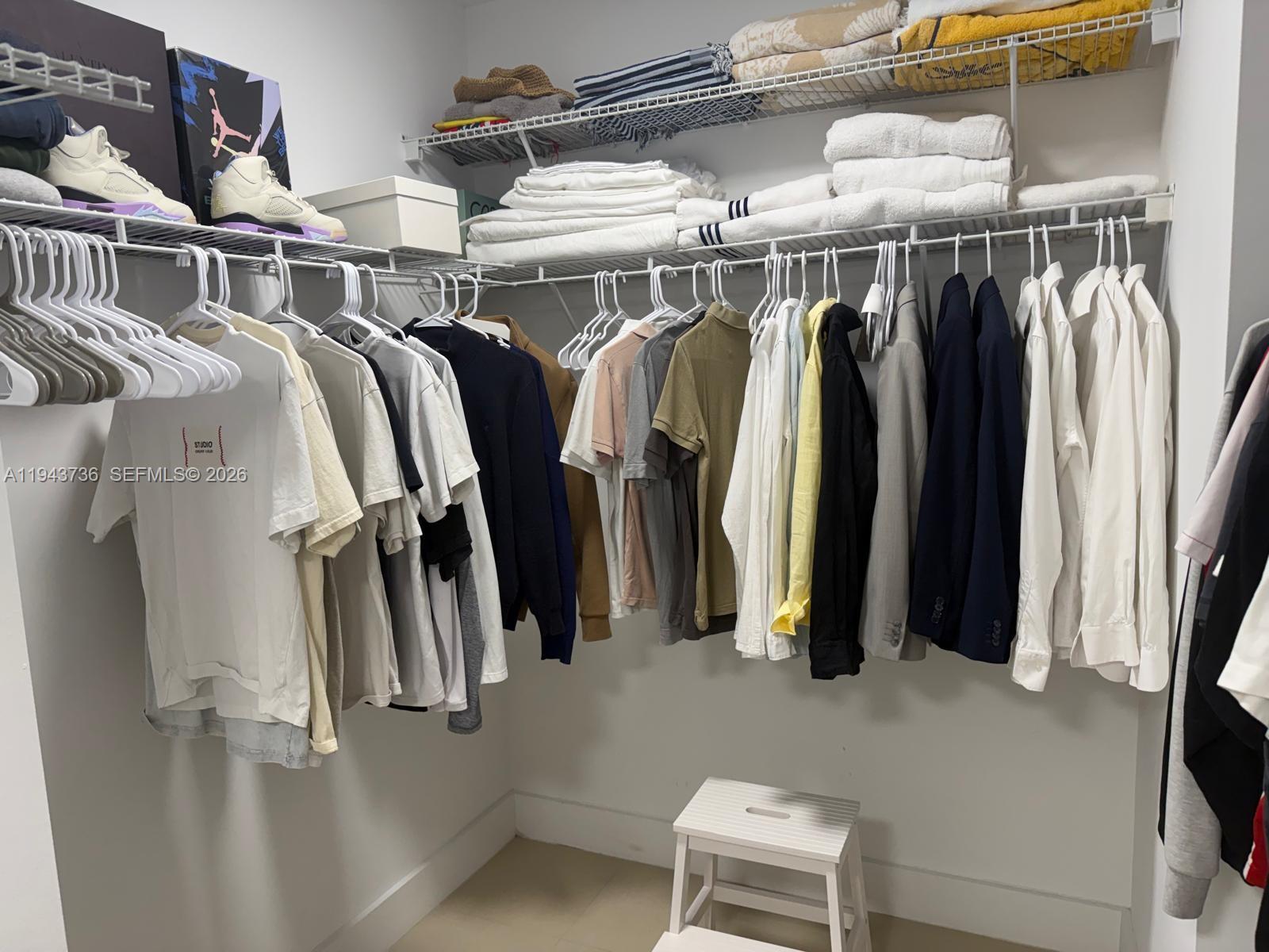 41 Southeast 5th Street, Unit 2010 Miami, FL 33131 - Photo 31 of 58 a view of walk in closet with clothes and shoes