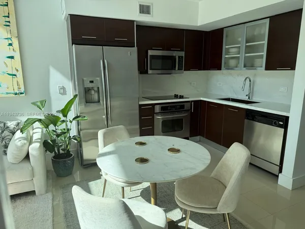 a dining room with furniture and a floor to ceiling window