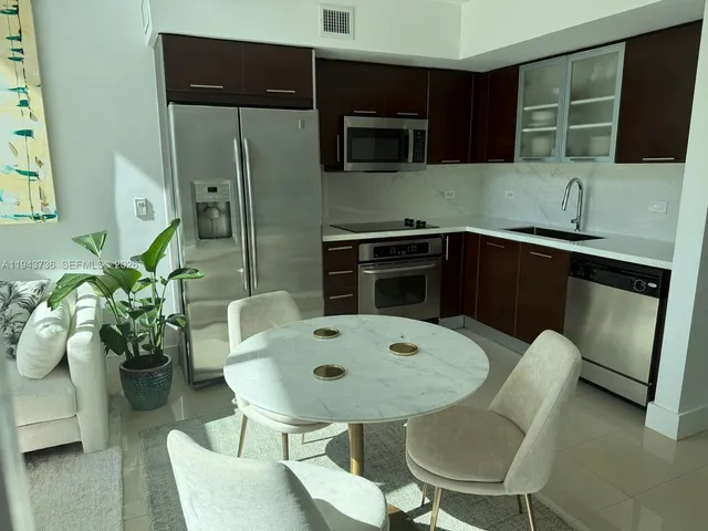 a dining room with furniture and a floor to ceiling window