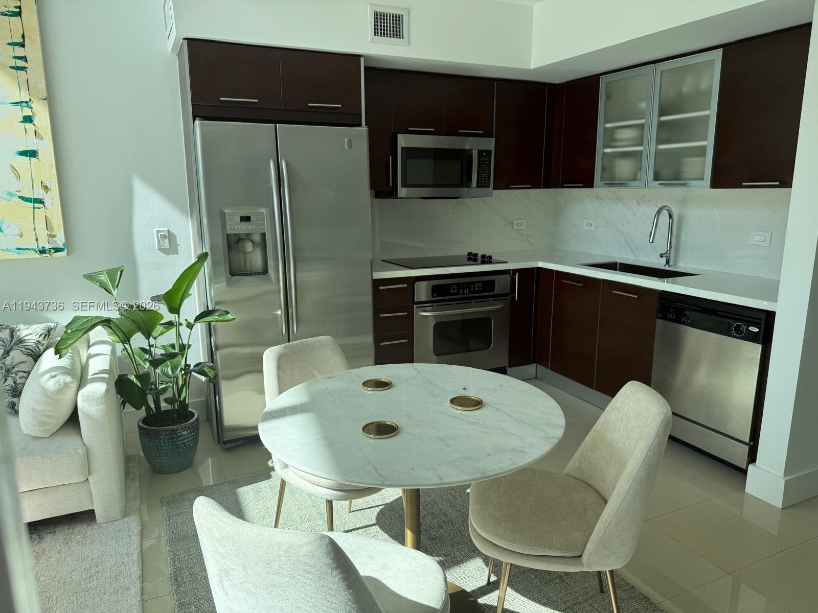 41 Southeast 5th Street, Unit 2010 Miami, FL 33131 - Photo 32 of 58 a kitchen with a table and chairs in it