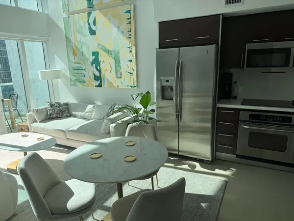 a living room with furniture and a floor to ceiling window