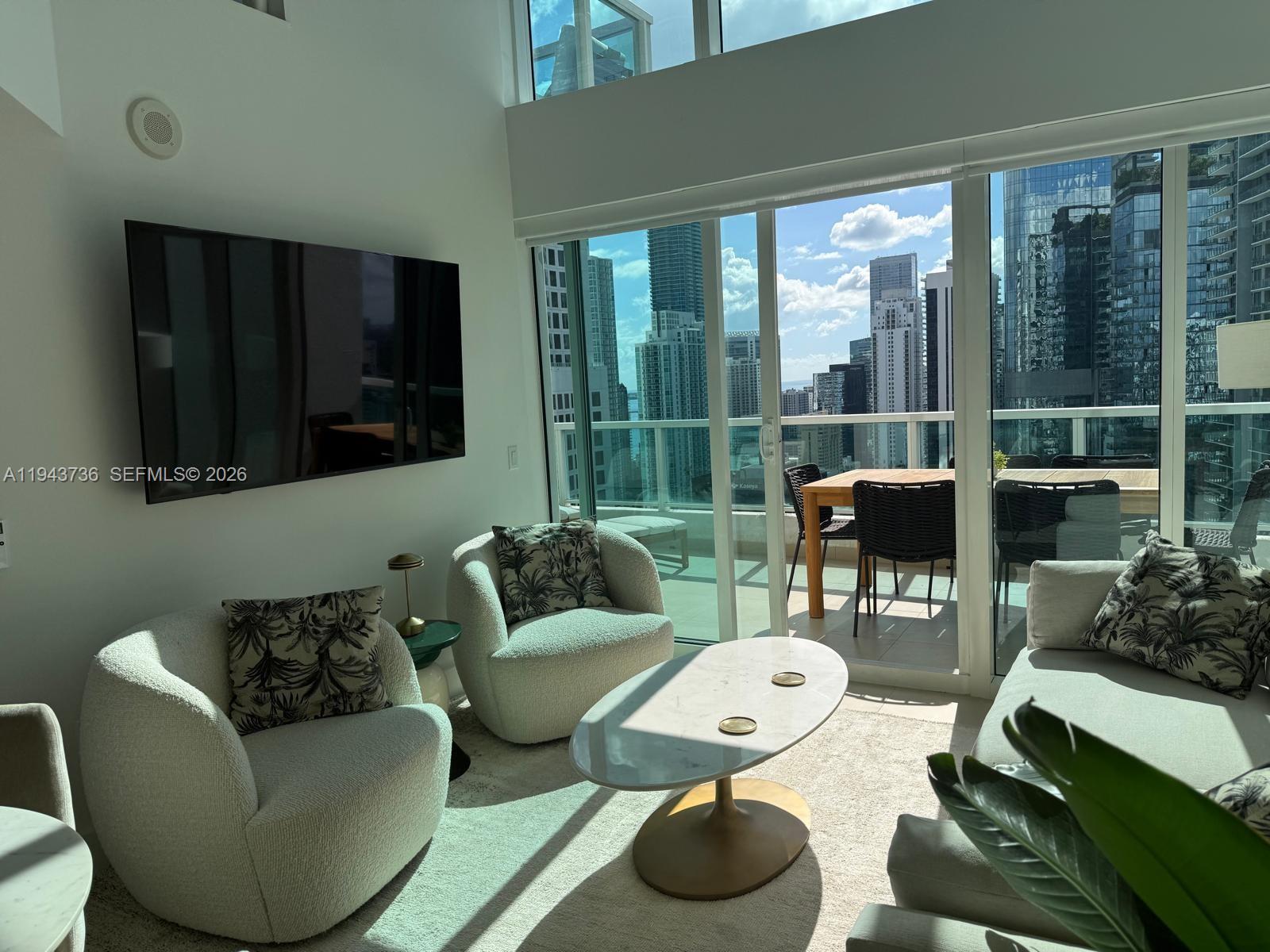 41 Southeast 5th Street, Unit 2010 Miami, FL 33131 - Photo 39 of 58 a living room with furniture and a floor to ceiling window