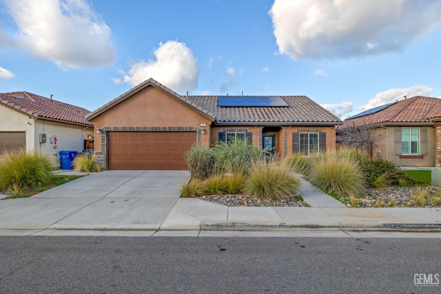 a front view of a house with a yard and potted plants