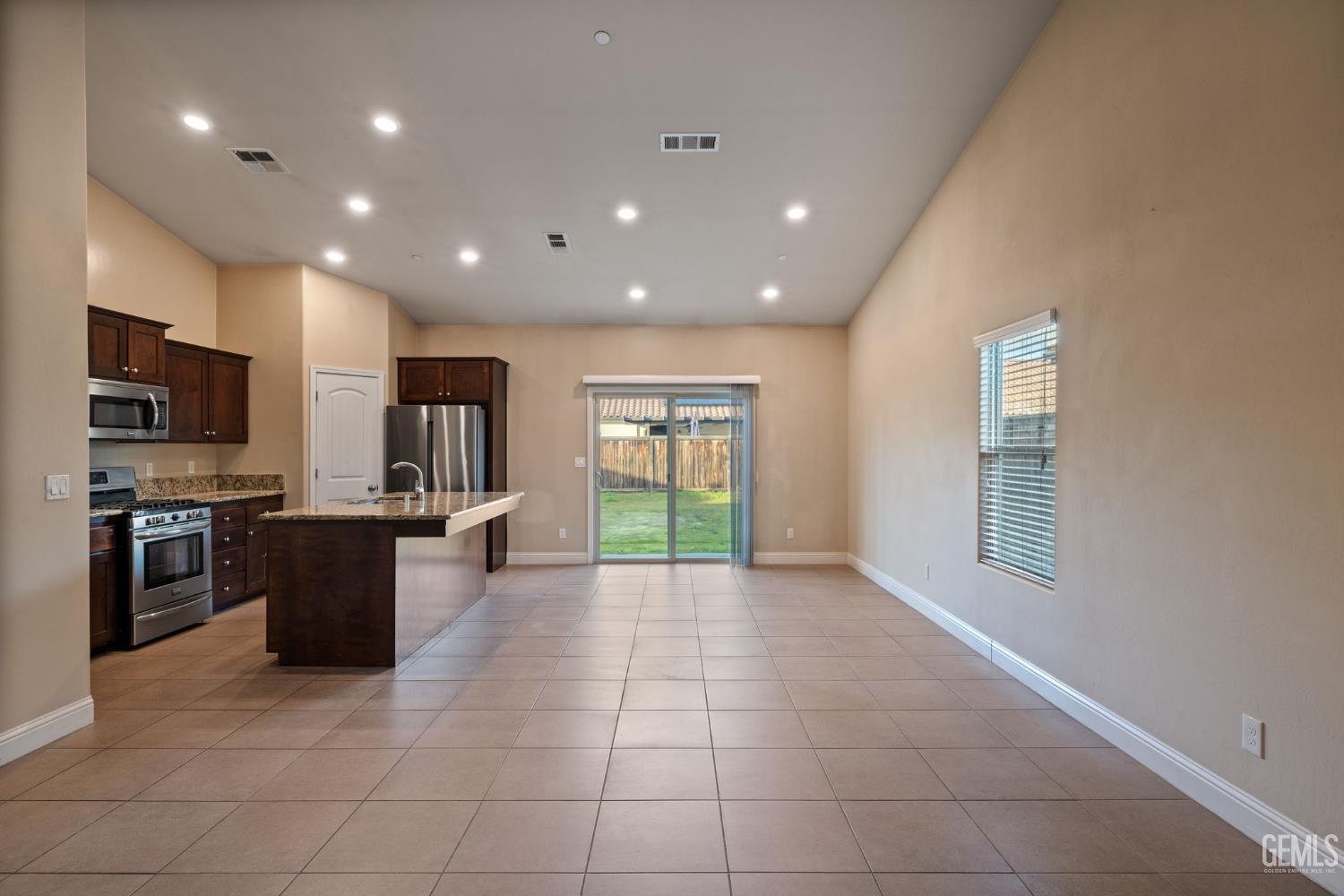 Undisclosed Address Shafter, CA 93263 - Photo 18 of 50 a view of a kitchen with kitchen island stainless steel appliances granite countertop a stove a sink a refrigerator counter space and cabinets