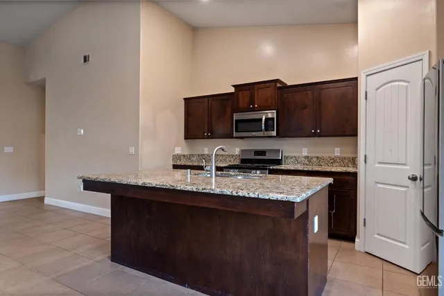 a kitchen with stainless steel appliances granite countertop a sink stove and microwave