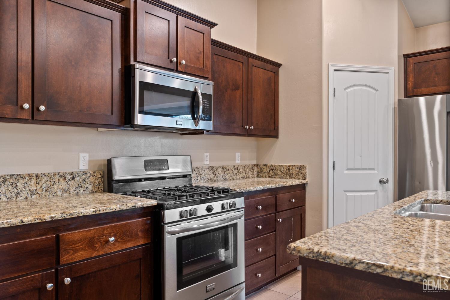 Undisclosed Address Shafter, CA 93263 - Photo 26 of 50 a kitchen with stainless steel appliances granite countertop a stove microwave and refrigerator