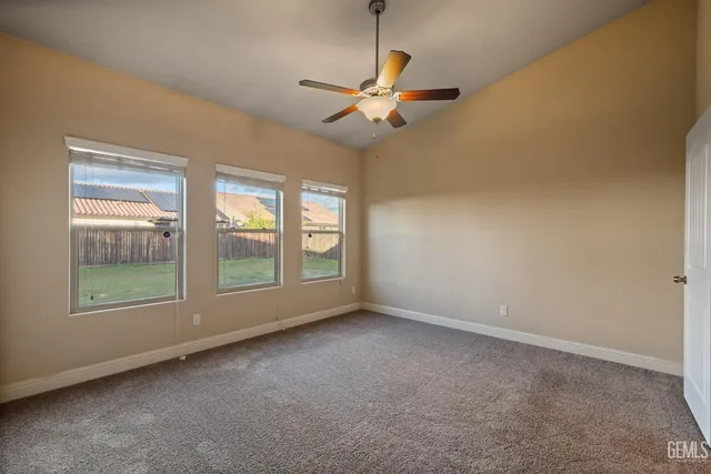 an empty room with windows and fan