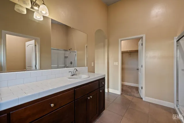 a spacious bathroom with a granite countertop sink and a mirror