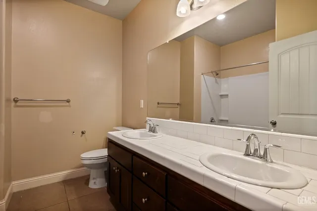 a bathroom with a granite countertop sink a toilet and a mirror