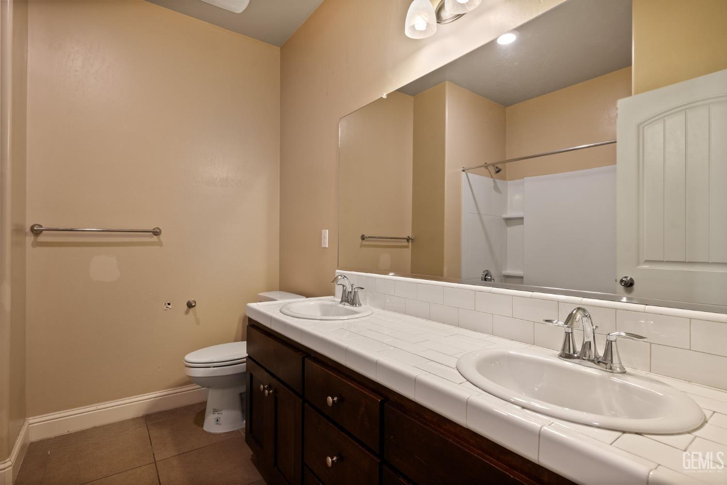 Undisclosed Address Shafter, CA 93263 - Photo 41 of 50 a bathroom with a granite countertop sink a toilet and a mirror
