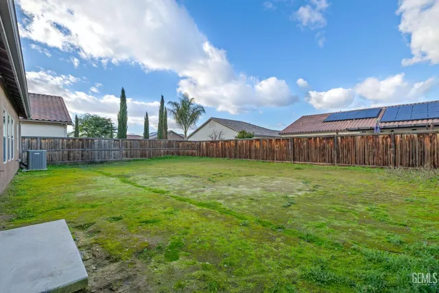 a view of a backyard with table and chairs with wooden fence